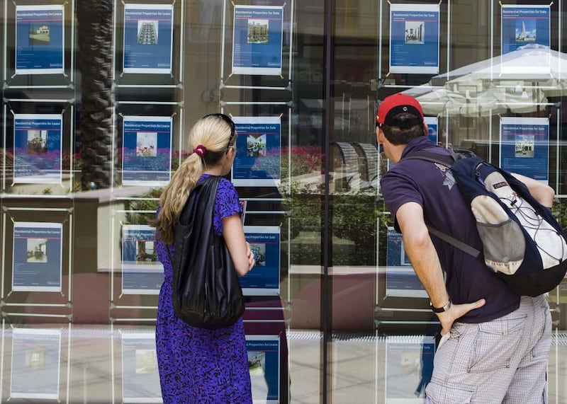 Customers brows the selection of property advertisements posted at the Better Homes office in Dubai. Lauren Lancaster / The National