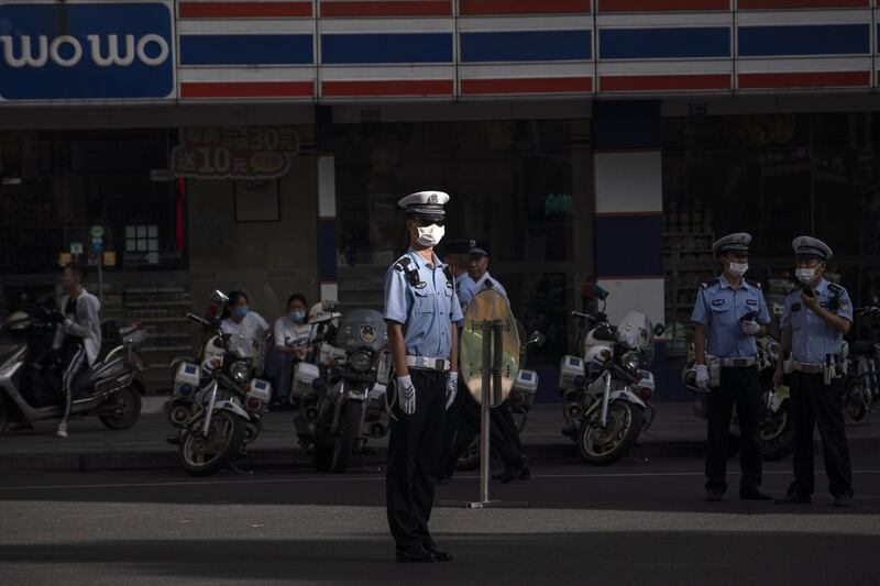 A police officer wearing a protective mask stands at a road block near the U.S. Consulate General in Chengdu, China. The U.S. lowered its flag over the American consulate in the Chinese city of Chengdu, the latest historic milestone marking the deterioration in relations between Washington and Beijing. Bloomberg