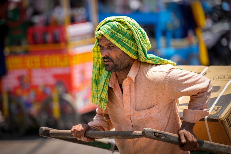 A man covers his head with a scarf as New Delhi records scorching temperatures as extreme heat strike parts of the country.  AP
