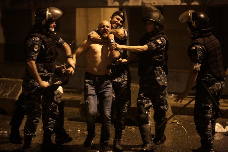 Lebanese riot police detain an anti-government protester during a protest against government's plans to impose new taxes in Beirut, Lebanon. AP Photo