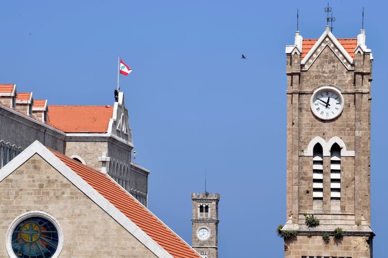 The clock tower of the Lebanese government palace, back, and the clock of the National Evangelical Church are seen in downtown Beirut last month. EPA