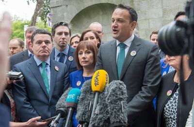 Ireland's Prime Minister Leo Varadkar (R) addresses the media after posing with ctivists from the "Yes" campaign, urging people to vote 'yes' in the referendum to repeal the eighth amendment of the Irish constitution, during a photocall in Dublin on May 24, 2018. Ireland will hold a referendum on May 25 on whether to alter its constitution to legalise abortion. The Eighth Amendment of the Irish constitution recognises the equal right to life of the unborn and the mother. Abortion is illegal unless there is a real and substantial risk to the life of the mother, and a woman convicted of having an illegal termination faces 14 years imprisonment. / AFP / BARRY CRONIN
