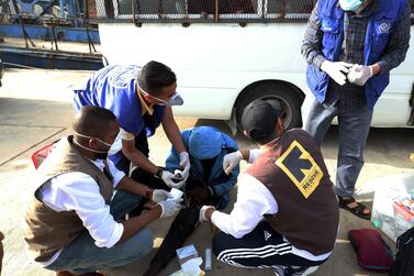 Aid workers tend to a migrant arriving at the naval base in Tripoli after the coastguard intercepted an inflatable boat carrying Europe-bound migrants. AFP