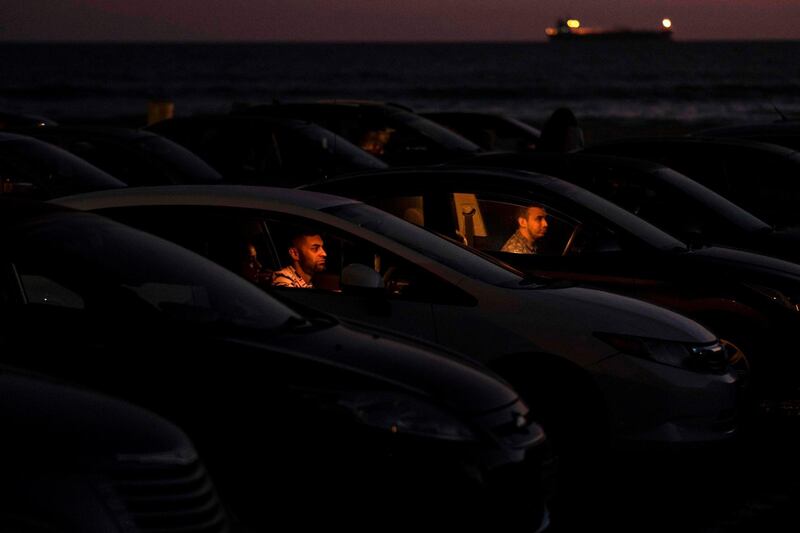 People attend a drive in cinema on the beach in Playas de Rosarito, Baja California state, Mexico.  AFP