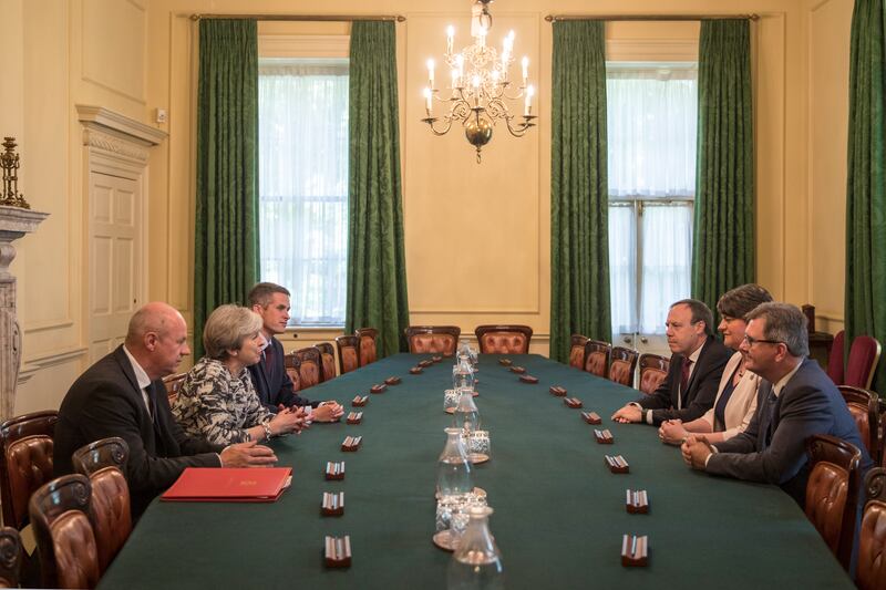 Former prime minister Theresa May sits with Gavin Williamson on her left as they talk with Democratic Unionist Party officials inside 10 Downing Street in June 2017. Getty Images