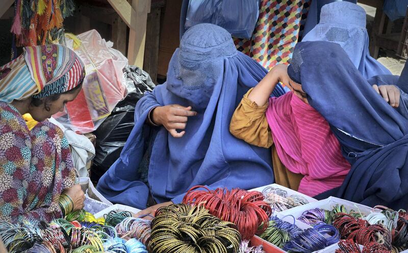 Afghan refugee women buy bangles at a roadside stall ahead of the Eid al-Fitr holiday which marks the end of Ramadan in Pakistan's northwestern city of Peshawar on June 14, 2018.
Muslims around the world are preparing to celebrate the Eid al-Fitr holiday, which marks the end of the fasting month of Ramadan. / AFP PHOTO / ABDUL MAJEED
