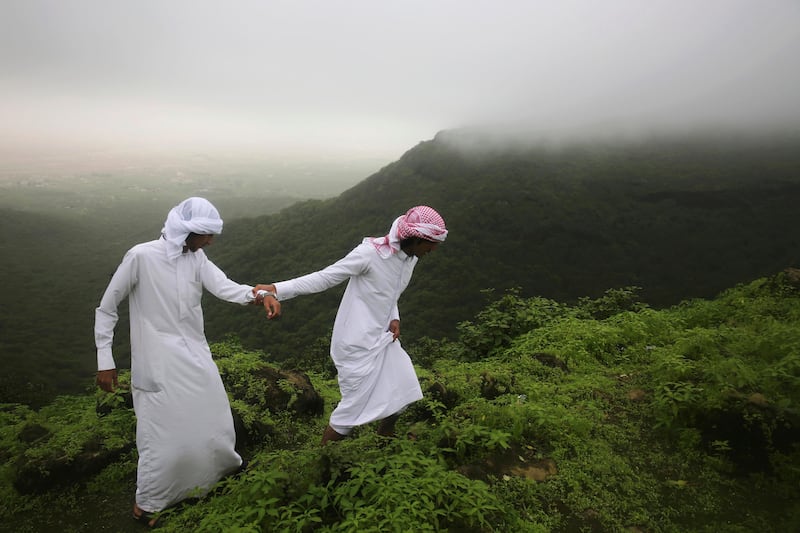
                  <p>FILE -- In this Aug. 2, 2017 file photo, Mohammad al-Bariki, right, 17, leads his half-brother Sagheer al-Bariki, 17, across a cliff ledge in the Jabal Ayoub mountains north of Salalah, Oman. The foggy monsoon season draws thousands of visitors seeking relief from high temperatures elsewhere in the Arab world. The season lasts three months, starting this year June 21. (AP Photo/Sam McNeil, File)</p>
               