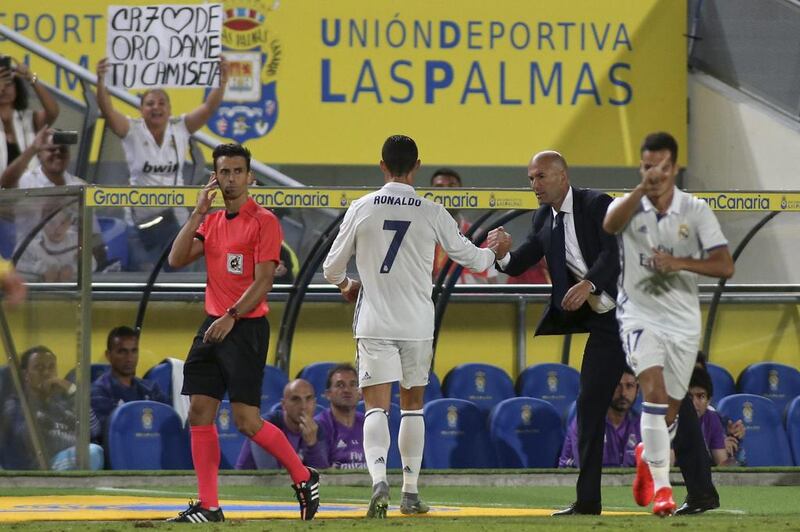 Real Madrid’s Cristiano Ronaldo, centre, shakes hands with Zinedine Zidane after being substituted. Jesus de Leon / AP Photo