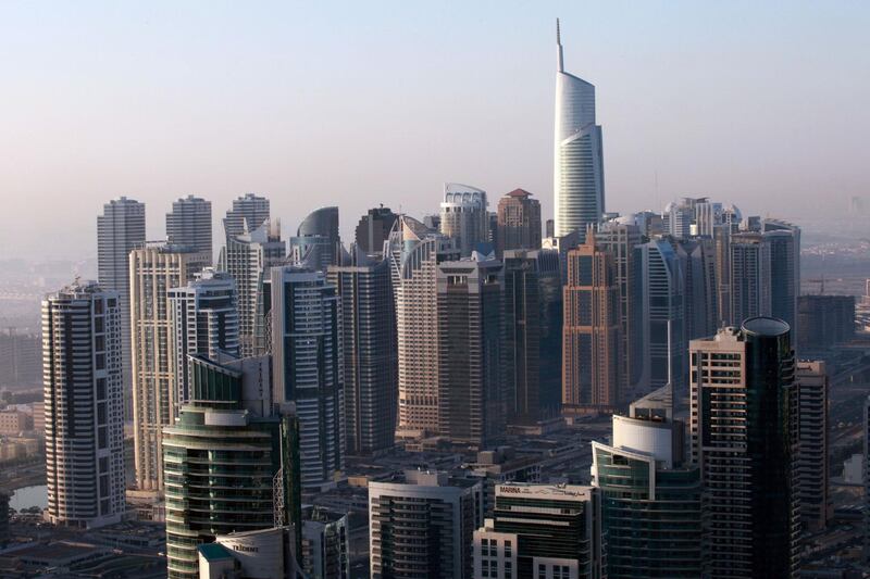 The Almas tower, right, stands above other skyscrapers at the Jumeirah Lake Towers development in Dubai, United Arab Emirates, on Sunday, Dec. 11, 2011. Dubai and its state-owned non-financial companies have $101.5 billion of outstanding debt and may need further financial support to meet those obligations, Moody's said. Photographer: Gabriela Maj/Bloomberg