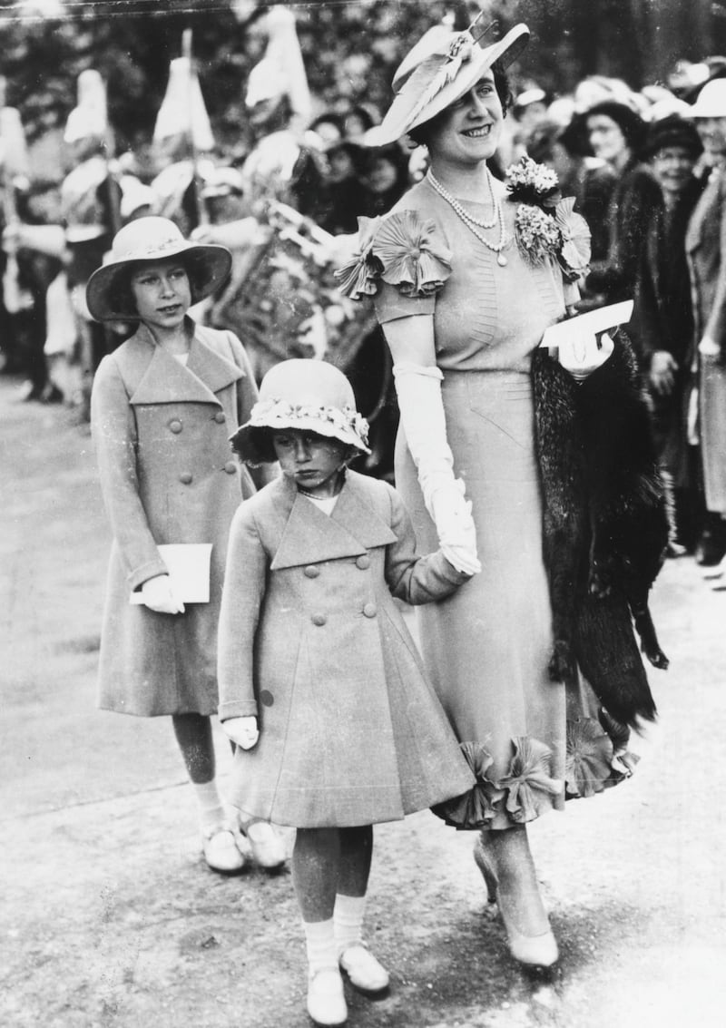 Queen consort Elizabeth holding Princess Margaret's hand as Princess Elizabeth follows, attending the Elphinstone wedding, 1936. (Photo by Central Press/Hulton Archive/Getty Images)