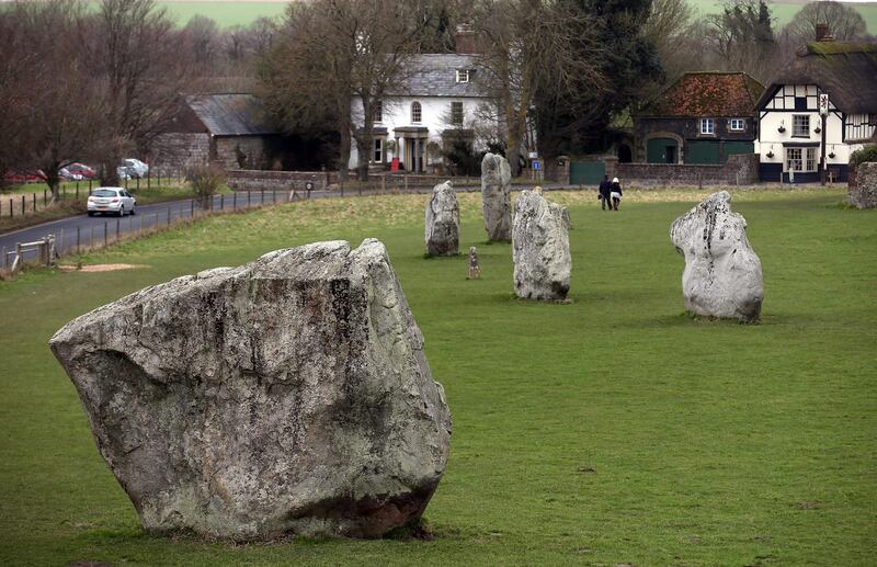 AVEBURY, UNITED KINGDOM - FEBRUARY 07:  Visitors walk besides the Neolithic stones at Avebury on February 7, 2013 in Wiltshire, England. A leading travel magazine has recently named the collection of stones - thought to have been constructed around 2600BC and the largest stone circle in Europe, as the second best heritage site in the world. The Wiltshire world heritage site has been placed ahead of much more recognisable sites including the Valley of the Kings in Egypt, Taj Mahal in India and the Forbidden City in China.  (Photo by Matt Cardy/Getty Images)