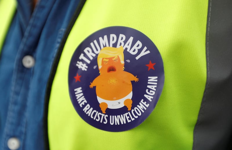 A demonstrator wears a badge depicting Trump as a baby. Reuters