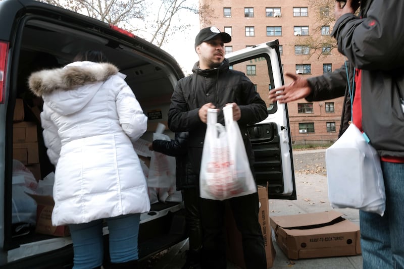 Needy people receive a free Thanksgiving turkey and other holiday food staples in New York City. Getty Images / AFP