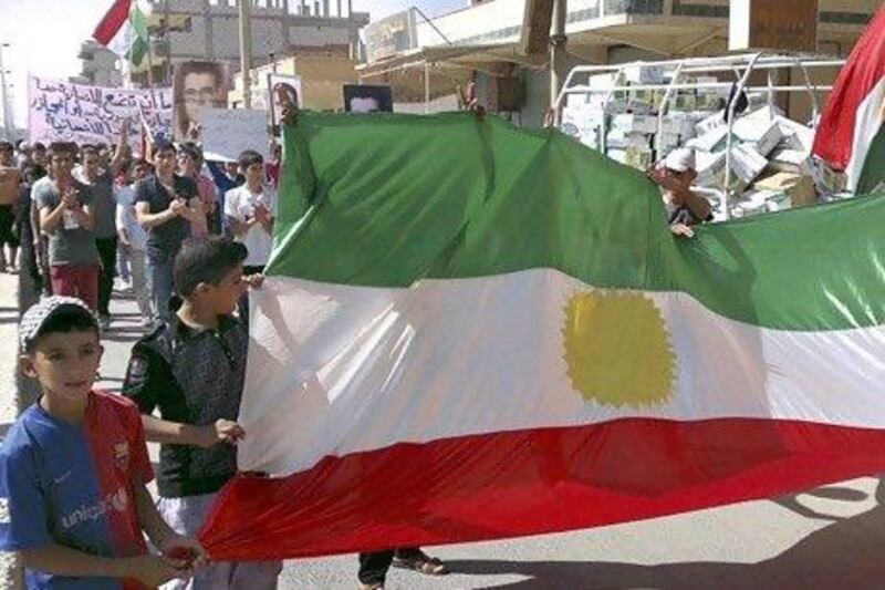 Demonstrators hold a Kurdish flag during a protest against Syria's President Bashar al-Assad after Friday Prayers in Al-Qamishli.