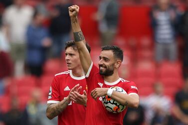 Manchester United's Portuguese midfielder Bruno Fernandes holds the match ball as he reacts at the final whistle during the English Premier League football match between Manchester United and Leeds United at Old Trafford in Manchester, north west England, on August 14, 2021.  (Photo by Adrian DENNIS / AFP) / RESTRICTED TO EDITORIAL USE.  No use with unauthorized audio, video, data, fixture lists, club/league logos or 'live' services.  Online in-match use limited to 120 images.  An additional 40 images may be used in extra time.  No video emulation.  Social media in-match use limited to 120 images.  An additional 40 images may be used in extra time.  No use in betting publications, games or single club/league/player publications.   /  