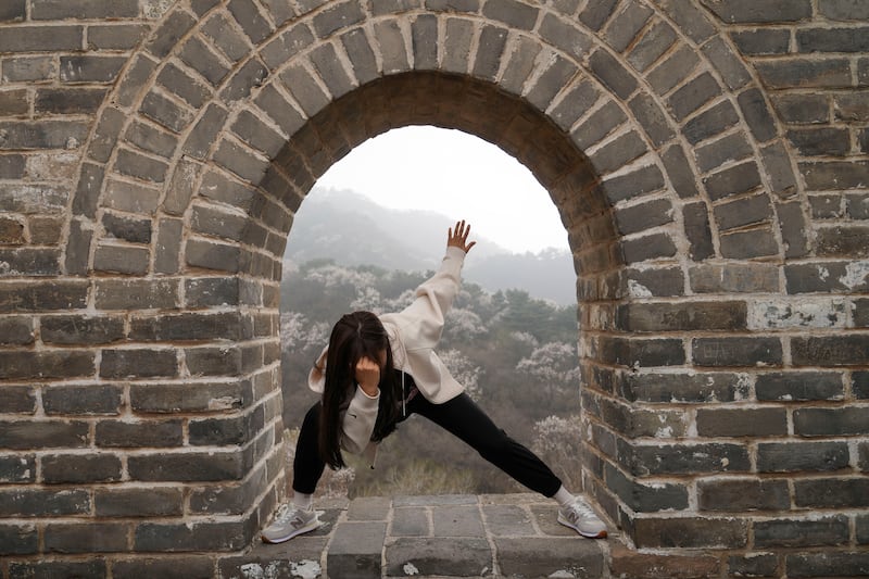 A woman poses for a photo at the Badaling Great Wall of China on the outskirts of Beijing. AP