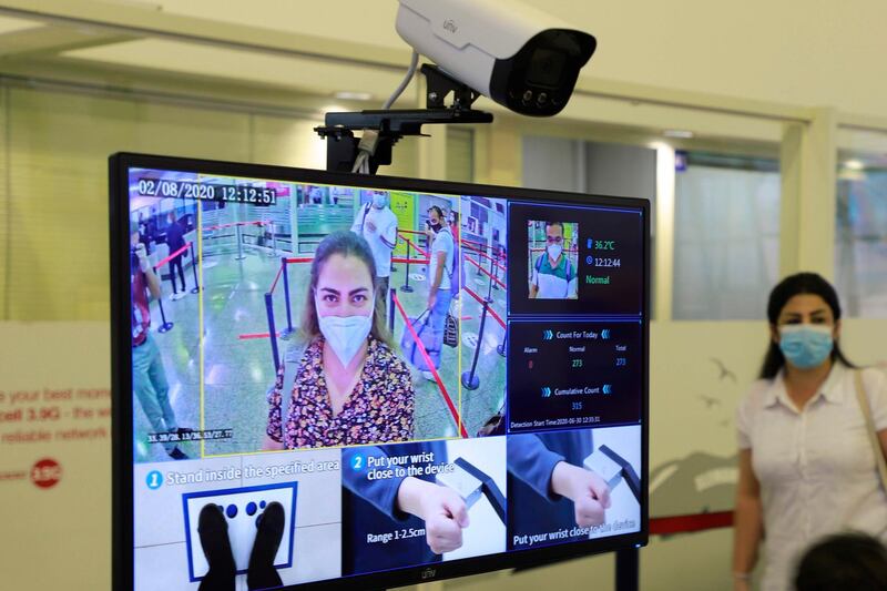 A traveller stands before a terminal equipped with a camera to scan body temperature at Sulaimaniya International Airport in Iraq's autonomous Kurdish region. AFP