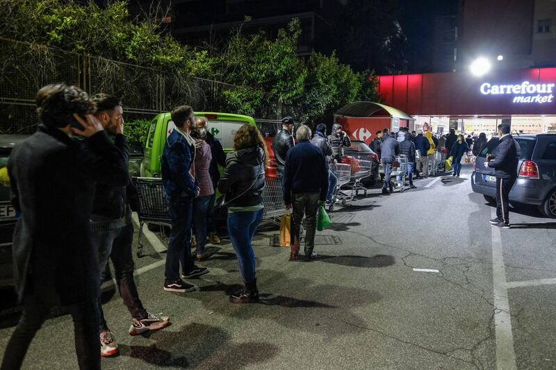 Roman citizens queue outside a supermarket as they wait to buy basic necessities, in Rome, Italy.  EPA