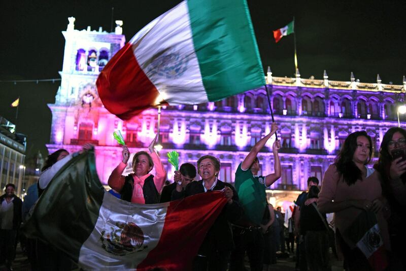 Supporters of the presidential candidate for the "Juntos haremos historia" coalition, Andres Manuel Lopez Obrador, celebrate at the Zocalo square in Mexico City, after getting the preliminary results of the general elections on July 1, 2018.  Anti-establishment leftist Andres Manuel Lopez Obrador won Mexico's presidential election Sunday by a large margin, according to exit polls, in a landmark break with the parties that have governed for nearly a century. Johan Ordonez / AFP
