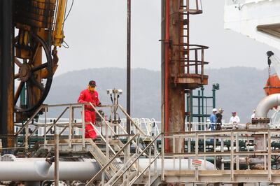 A Venezuelan oil worker walks in the El Palito refinery during the arrival of Iranian oil tanker Fortune near Puerto Cabello, Venezuela, Monday, May 25, 2020. The first of five tankers loaded with gasoline sent from Iran is expected to temporarily ease Venezuela's fuel crunch while defying Trump administration sanctions targeting the two U.S. foes. (AP Photo/Ernesto Vargas)