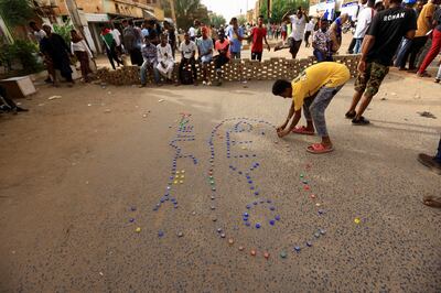 A protester arranges bottle caps to form the Arabic word 'madaniya', or civilian, during a rally against military rule in Sudan. Reuters