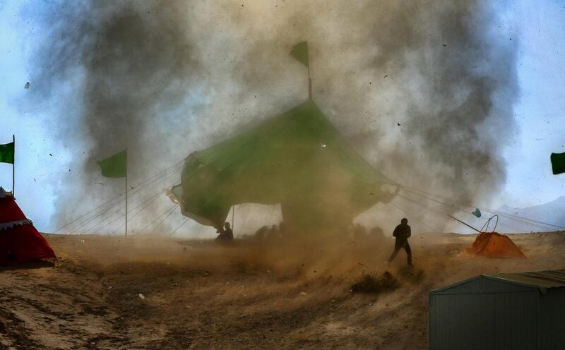 'Small Tornado', Hadi Dehghanpour: 'Every year, the Iranian people hold a glorious ritual to mourn during Muharram. This photo was taken before the start of the mourning ceremony in the historic city of Noshabad, Isfahan. A small tornado came towards the ceremony site and tore down the tents and benches.'