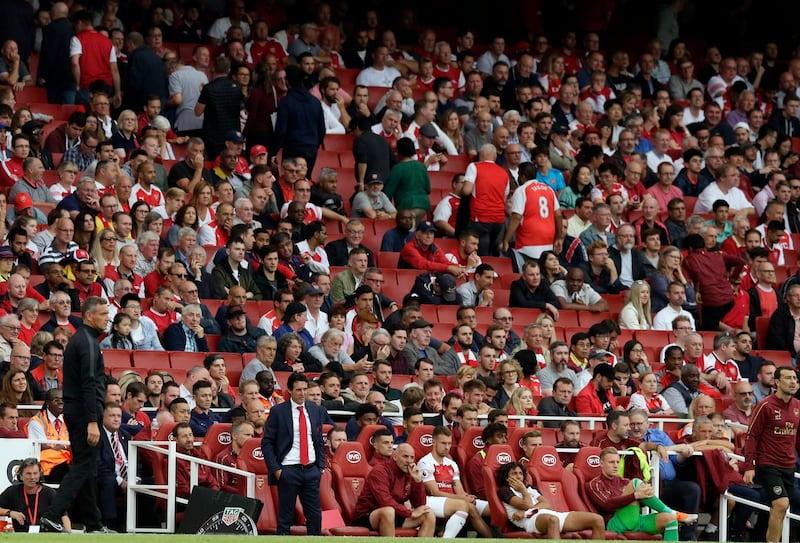 Arsenal manager Unai Emery, foreground center, stands by the bench as some team fans start leaving the stands before the end of the English Premier League soccer match between Arsenal and Manchester City at the Emirates stadium in London, England, Sunday, Aug. 12, 2018. (AP Photo/Tim Ireland)