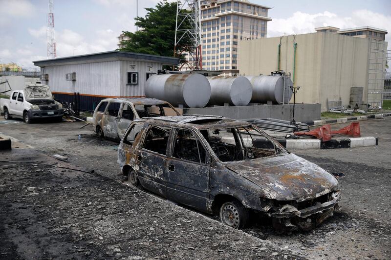 Burnt vehicles are seen near the Lekki toll gate, in Lagos. AP