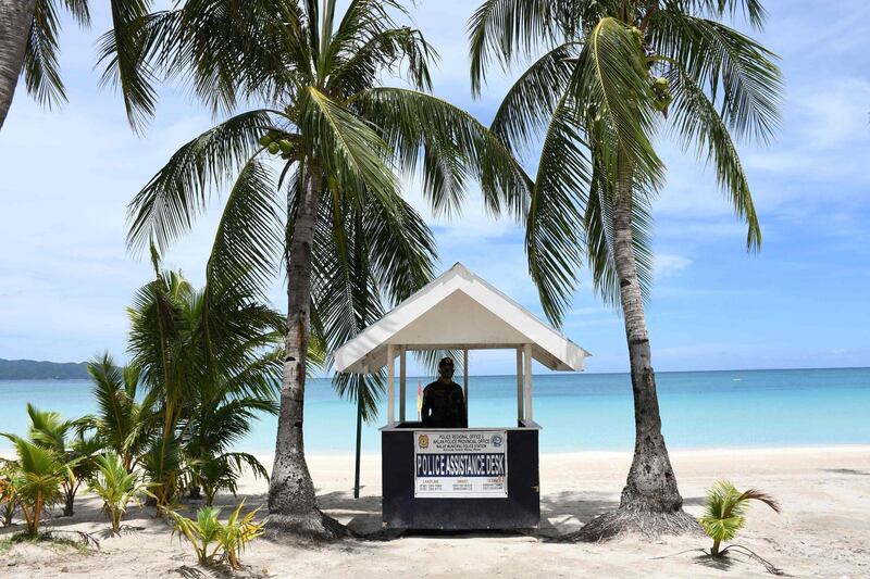 A policeman stands guard along the empty famous white beach of Boracay Island in central Philippines, as community quarantine against Covid19 still continues throughout the country, with foreign tourists still banned on beaches. AFP