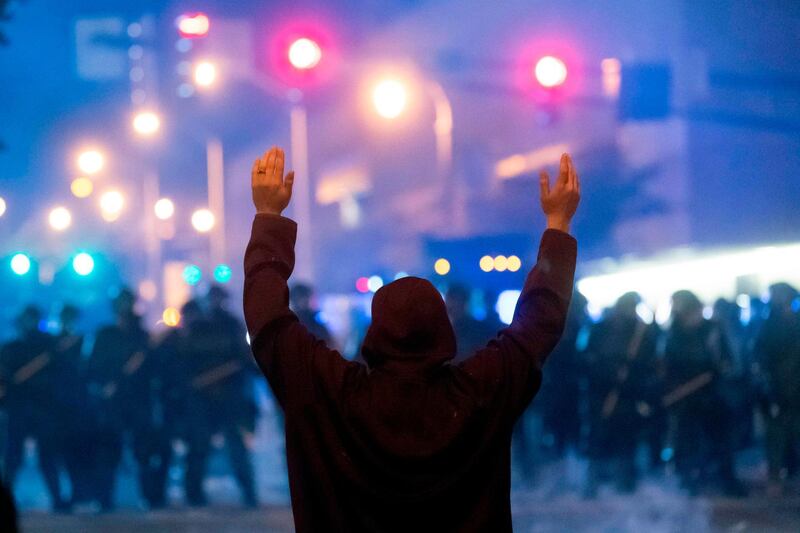 A protester faces off with police during rioting and protests in Atlanta.  AFP
