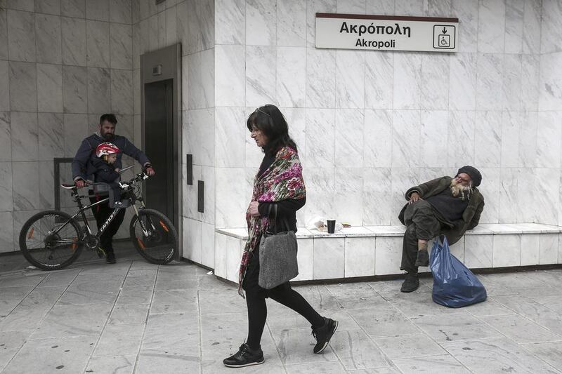 A woman passes the front of the Acropolis metro station in Athens on Saturday. Greece and its international creditors are still struggling to agree on a list of economic reforms that are deemed necessary for the country to unlock emergency funds and stay afloat. Yorgos Karahalis / AP Photo