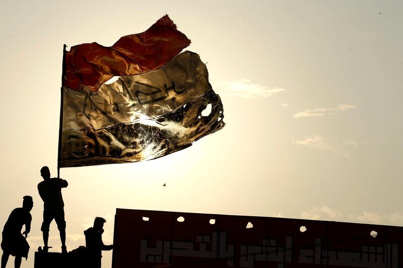 An Iraqi demonstrator carries an Iraqi flag during ongoing anti-government protests, in Baghdad. Reuters