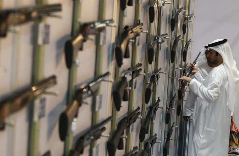 An Emirati man looks at a rifle during the first day of ADIHEX. Karim Sahib / AFP Photo