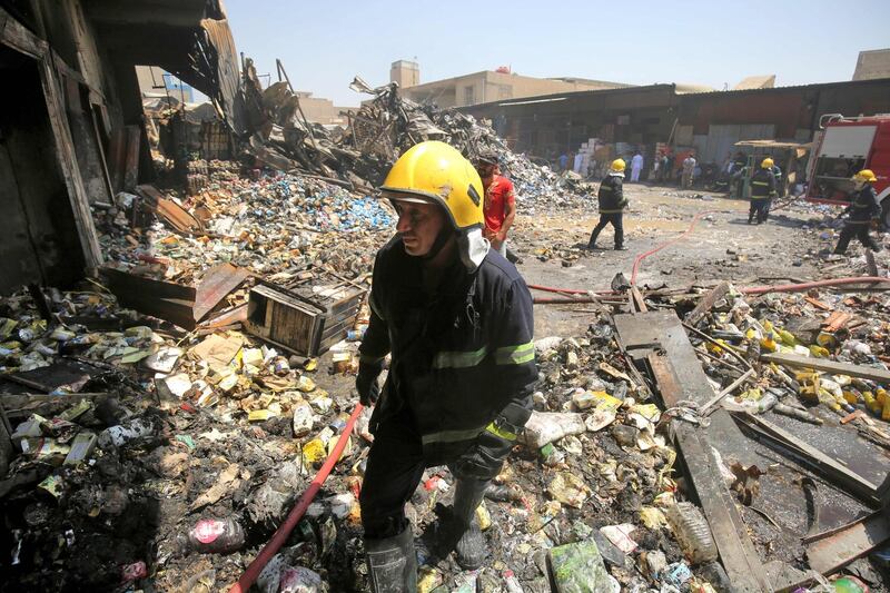 Iraqi firefighters inspect the charred remains of a warehouse in Baghdad's Sadr City on August 23, 2019, after a large fire broke out overnight.  / AFP / AHMAD AL-RUBAYE
