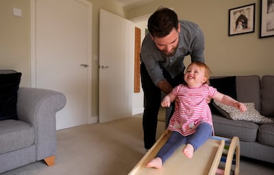 Opal Sandy, who was born completely deaf because of a rare genetic condition and can now hear unaided for the first time, plays with her father. PA