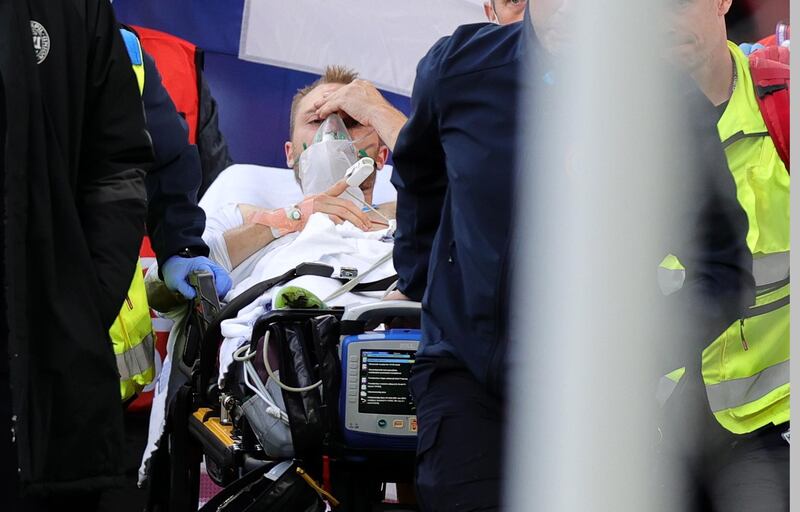 epa09266204 Christian Eriksen (C) of Denmark is stretchered off the pitch after receiving medical assistance during the UEFA EURO 2020 group B preliminary round soccer match between Denmark and Finland in Copenhagen, Denmark, 12 June 2021.  EPA/Friedemann Vogel / POOL (RESTRICTIONS: For editorial news reporting purposes only. Images must appear as still images and must not emulate match action video footage. Photographs published in online publications shall have an interval of at least 20 seconds between the posting.)