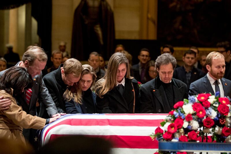 Neil Bush, second from left, and members of his family pay their respects. AP Photo