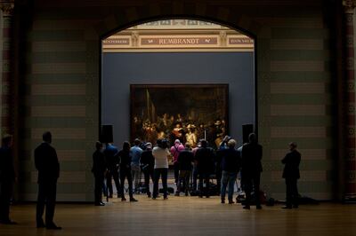 Journalists attend a press conference where the announcement was made that Rembrandt's Night Watch, rear, will be restored next year in the public eye at the Rijksmuseum in Amsterdam, Netherlands, Tuesday, Oct. 16, 2018. (AP Photo/Peter Dejong)