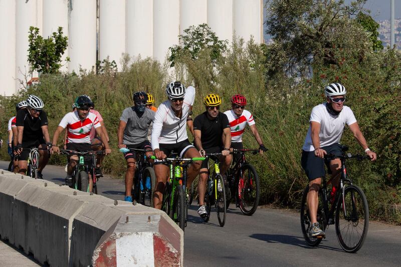 Former American professional cyclist Lance Armstrong, right, rides with Lebanese and foreign cyclists at the site of the August 4 deadly blast in the port of Beirut.  AP