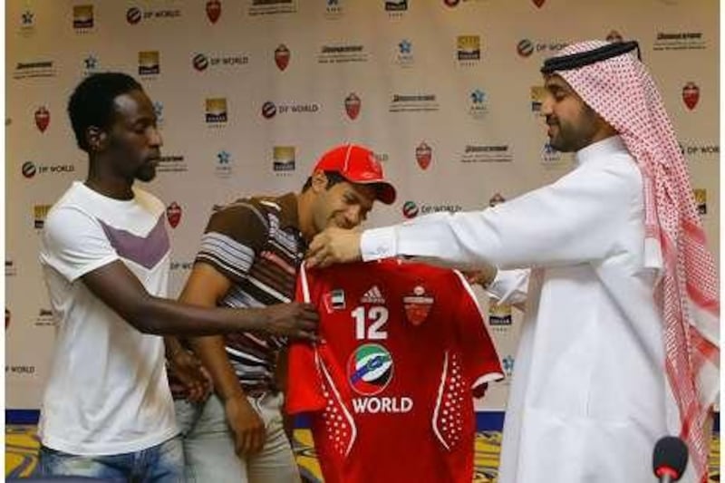 Hosny Abd Rabo, centre, is welcomed by the Al Ahli club chairman Khalifa Saeed Suleiman, right, and the captain Salem Khamis. Jeffrey E. Biteng / The National