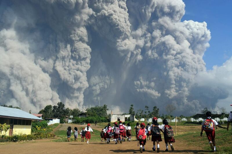 School children walk as Mount Sinabung erupts in Karo, North Sumatra, Indonesia. Sarianto / AP Photo