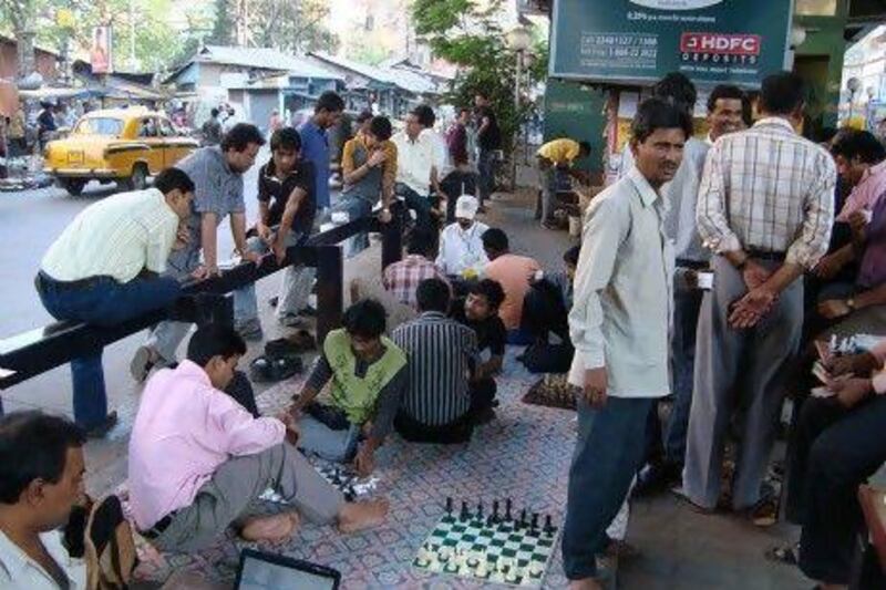 Members of the Gariahat Chess Club play while exposed to the elements amid the cacophonous traffic of Kolkata.
