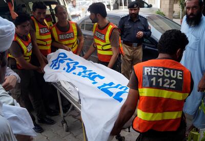 Rescue workers move the body of Ikramullah Gandapur, a candidate from opposition leader Imran Khan's party, who was killed in the suicide bombing, for postmortem at a hospital in Dera Ismail Khan, Pakistan, Sunday, July 22, 2018. A suicide bombing on Sunday in northwestern Pakistan killed a candidate running for a seat in the provincial assembly and his driver, and wounded three other people, police said. (AP Photo/Ishtiaq Mahsud)