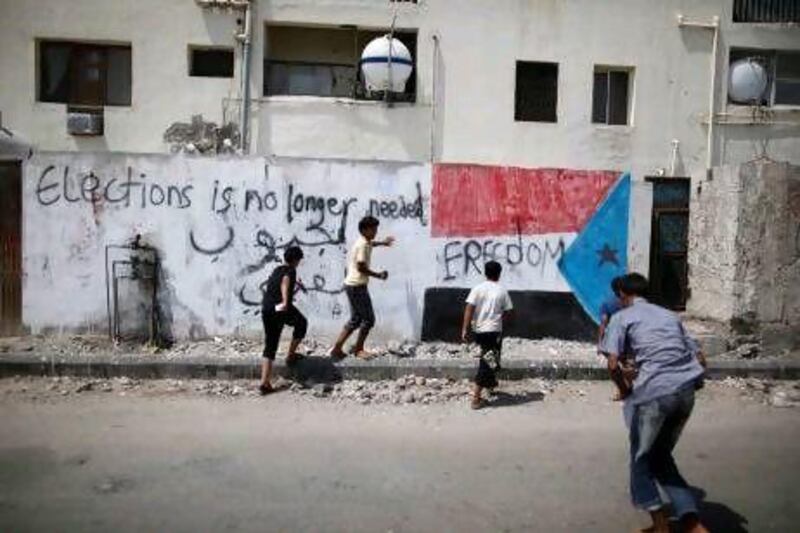 In the south Yemen city of Aden, graffiti shows a reversed image of the flag of former South Yemen and derides today's election.