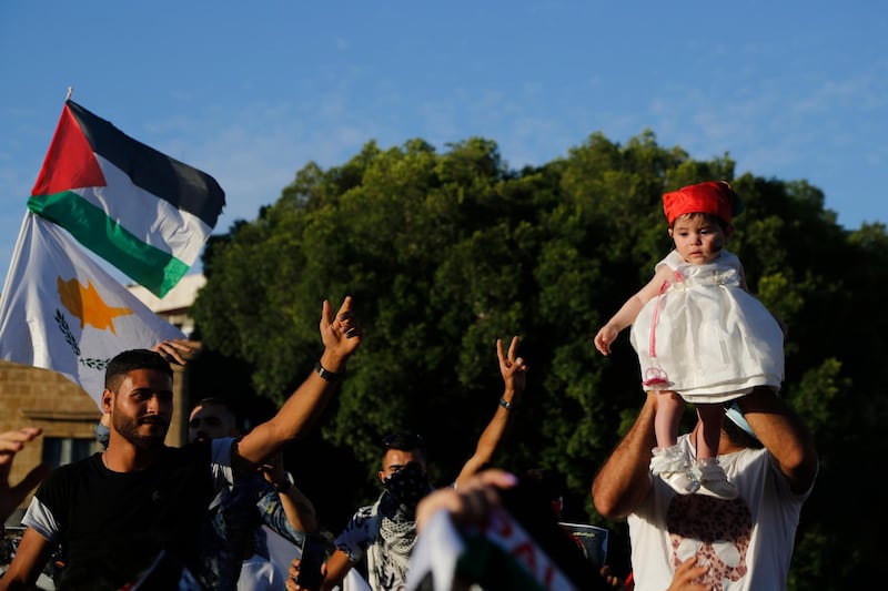 A Palestinian father living in Cyprus holds up his child during a protest at Elephtheria square in the capital Nicosia. AP Photo