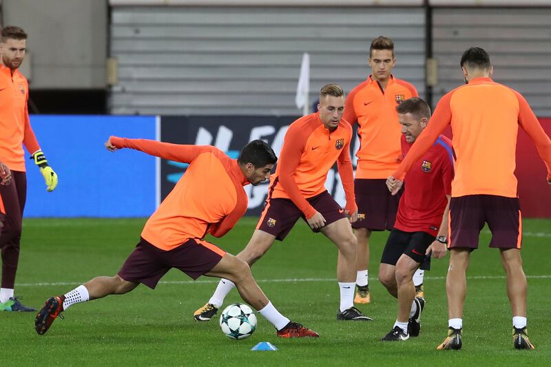Barcelona's Luis Suarez, second left , goes for the ball during a training session. Petros Giannakouris / AP Photo