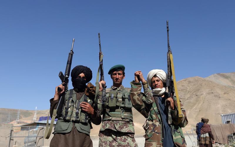 epa06814048 Alleged Taliban fighters and an Afghan national army soldier (C) stand for a photograph during a three-day ceasefire on the second day of Eid al-Fitr, in the outskirt of Kabul, Afghanistan, 16 June 2018. Earlier in the month, President Ghani's government had announced a temporary ceasefire, starting on 12 June, to last until the end of the festival. The Taliban had followed suit a few days later and announced a three-day partial ceasefire during the festival.  EPA/JAWAD JALALI