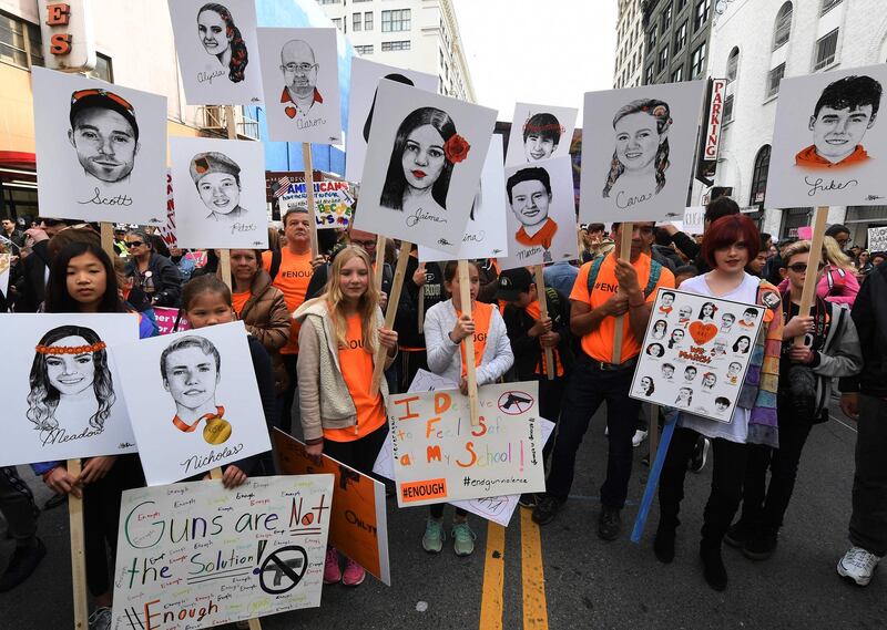 TOPSHOT - Students hold portraits of victims of Florida's Marjory Stoneman Douglas High School shootings as people protest for tighter gun laws during the student organized 'March For Our Lives' rally in Los Angeles, California on March 24, 2018.
Galvanized by a massacre at a Florida high school, hundreds of thousands of Americans are expected to take to the streets in cities across the United States on Saturday in the biggest protest for gun control in a generation. / AFP PHOTO / Mark Ralston