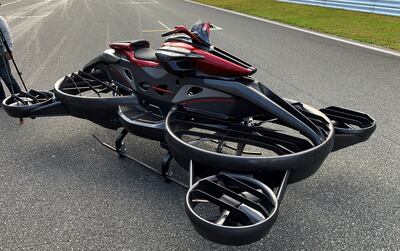 The black and red hoverbike consists of a motorcycle-like body on top of propellers. Photo: Reuters