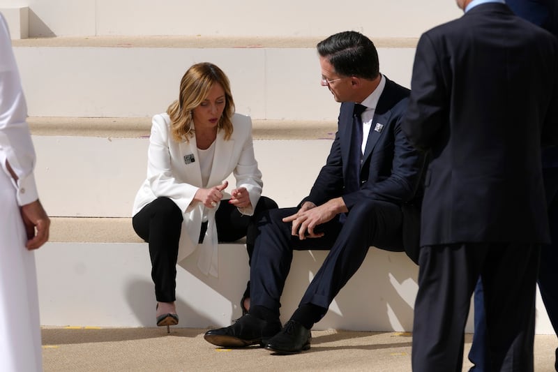 Italian Prime Minister Giorgia Meloni chatting to Netherlands Prime Minister Mark Rutte before the leaders' group photo. AP